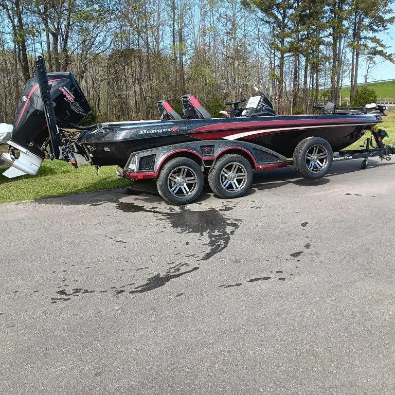Slide: The Image of 2025 Ranger Z520 boat on trailer, parked outdoors, with trees in background. - 1