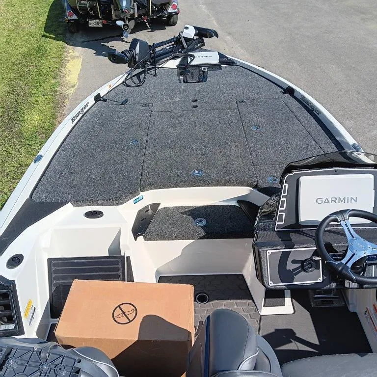 Slide: The Image of 2025 Ranger Z520 boat interior with Garmin system and cardboard box on deck. - 3