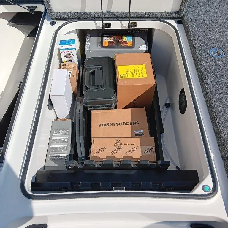 Slide: The Image of Storage compartment of 2025 Ranger Z520 boat filled with various boxes and equipment. - 5