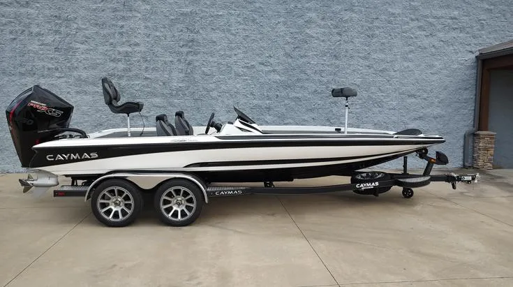The Image of 2025 Caymas CX21 Pro boat on trailer, sleek design, parked on concrete surface. - 1