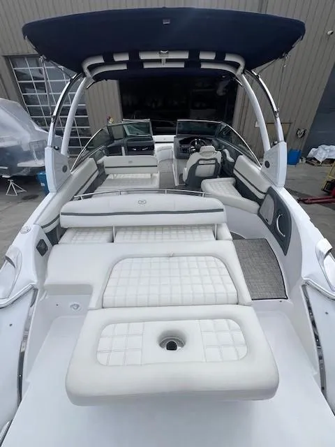 Slide: The Image of 2018 Cobalt R5 boat with white cushioned seating and blue canopy in a marina setting. - 17