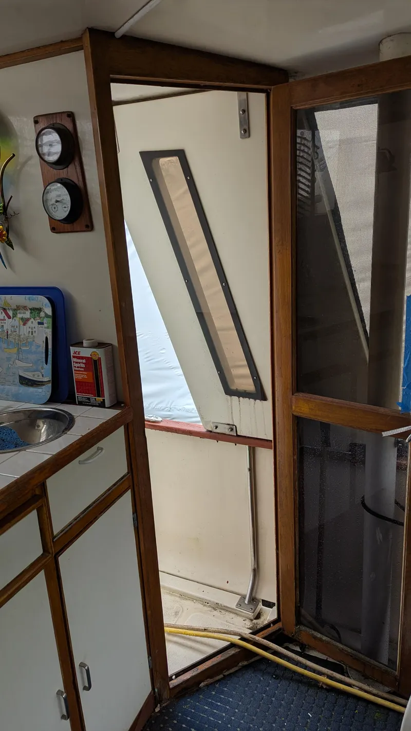 Slide: The Image of Interior view of 1989 Jefferson 42 SE Sundeck Motor Yacht, featuring a door and kitchenette area. - 12