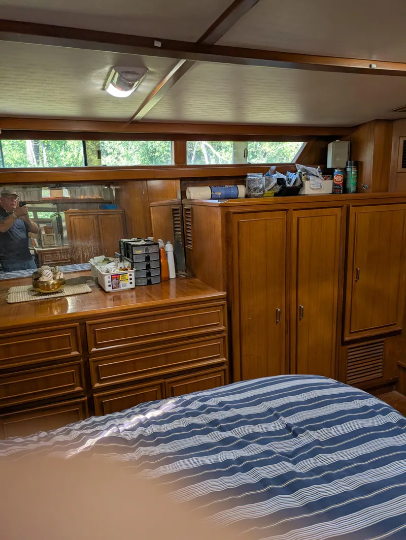 Slide: The Image of Interior of 1989 Jefferson 42 SE Sundeck Motor Yacht with wooden cabinets and striped bedding. - 13