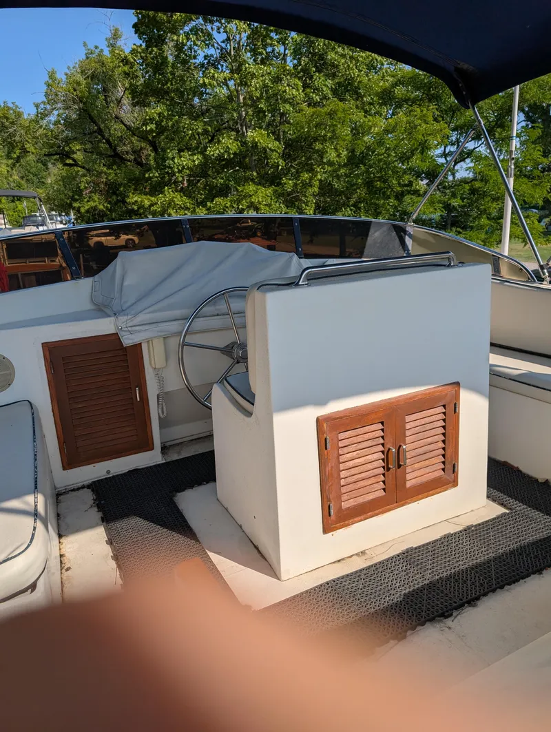 Slide: The Image of 1989 Jefferson 42 SE Sundeck Motor Yacht helm with covered steering wheel and wooden cabinets. - 15