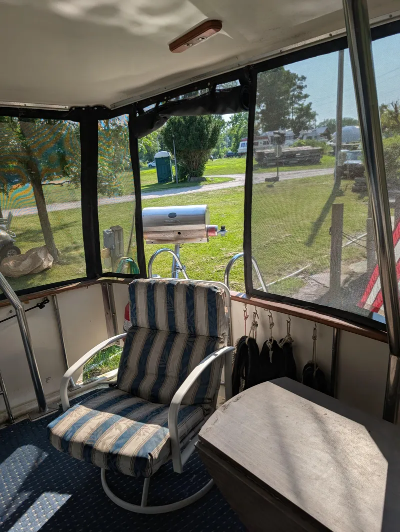 Slide: The Image of 1989 Jefferson 42 SE Sundeck Motor Yacht interior with striped chair and outdoor view. - 17