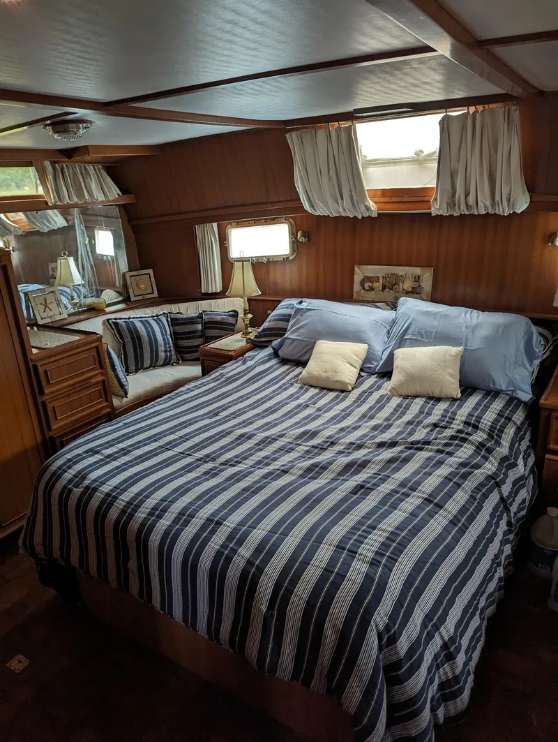 Slide: The Image of Cozy bedroom interior of 1989 Jefferson 42 SE Sundeck Motor Yacht with striped bedding. - 3