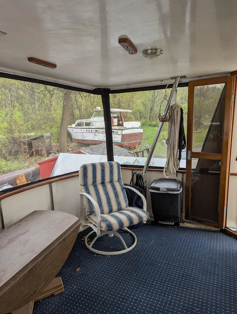 Slide: The Image of 1989 Jefferson 42 SE Sundeck Motor Yacht interior with chair and outdoor view. - 7