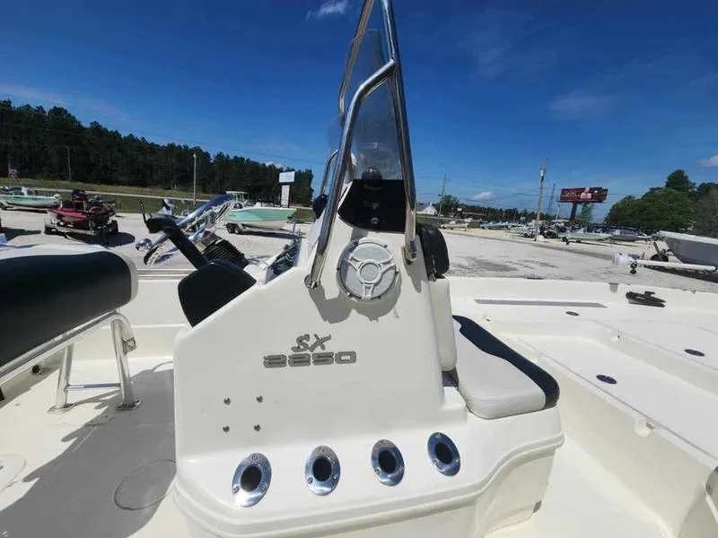Slide: The Image of 2014 Skeeter SX2250 boat console with steering wheel and seating, outdoors under clear sky. - 6