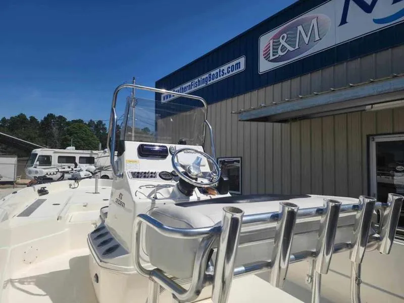 Slide: The Image of 2014 Skeeter SX2250 boat at dealership, featuring steering console and rod holders. - 8