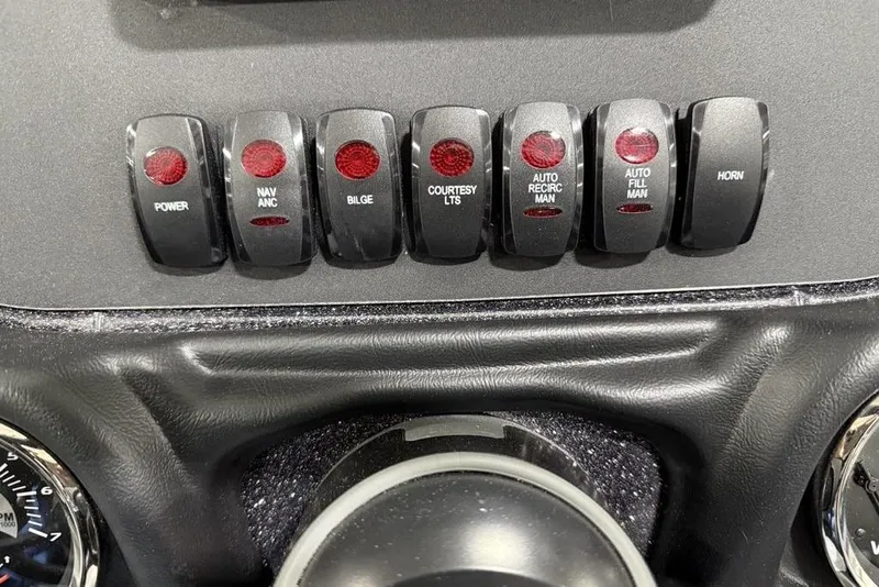 Slide: The Image of Dashboard switches of a 2025 Skeeter ZX150 boat, featuring various control functions. - 14