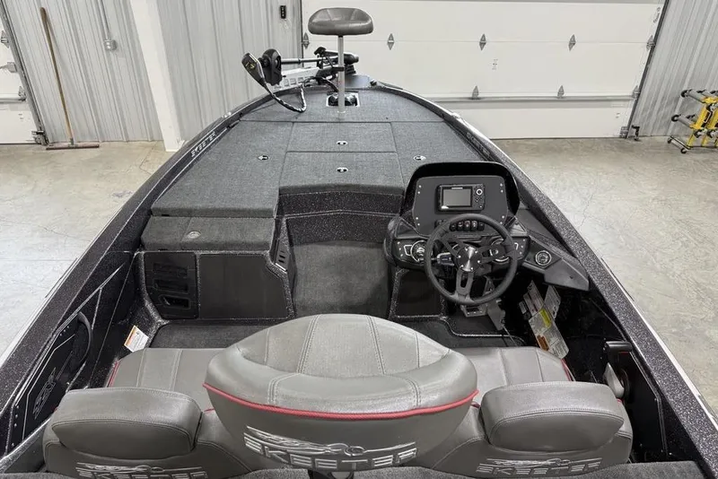 Slide: The Image of 2025 Skeeter ZX150 boat interior with steering console and seating in a garage. - 19