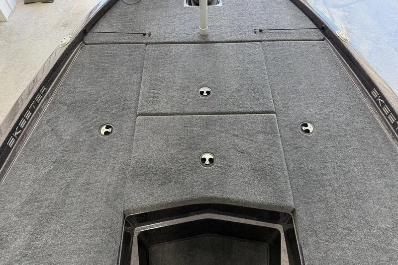 Slide: The Image of 2025 Skeeter ZX150 boat deck with storage compartments and gray carpeting. - 6