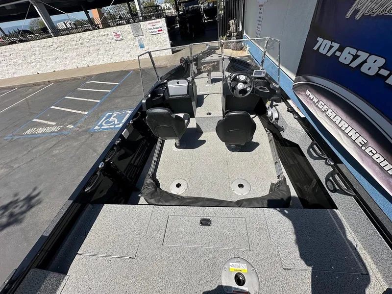 Slide: The Image of 2021 Crestliner 1700 Vision boat interior with dual seats and steering console in a parking lot. - 11