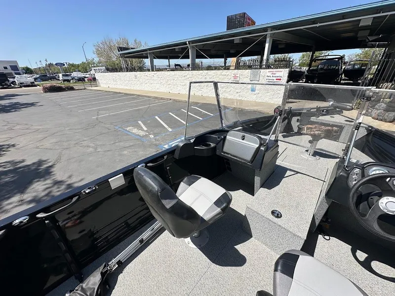 Slide: The Image of 2021 Crestliner 1700 Vision boat interior with seating and steering wheel in a parking lot. - 16