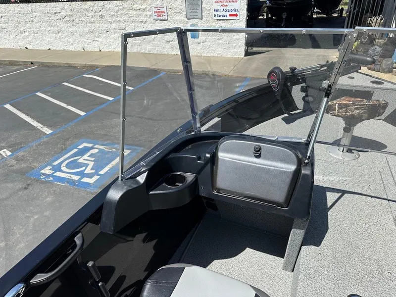 Slide: The Image of 2021 Crestliner 1700 Vision boat interior with windshield and seating in a parking lot. - 17