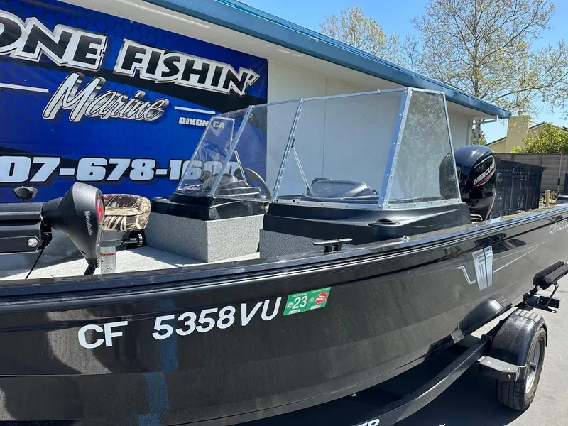 Slide: The Image of 2021 Crestliner 1700 Vision boat at dealership, side view with registration number visible. - 7