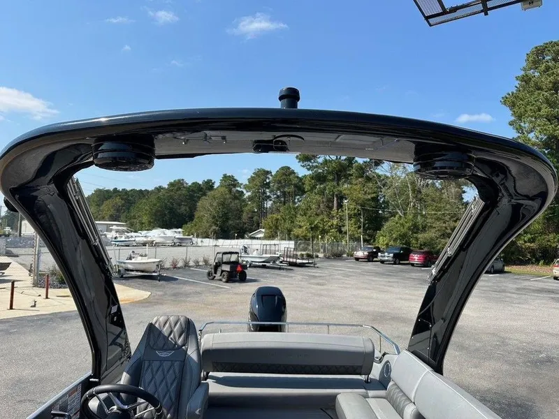 Slide: The Image of 2021 Bennington 25 RXSB boat with sleek design and spacious seating, parked outdoors. - 15