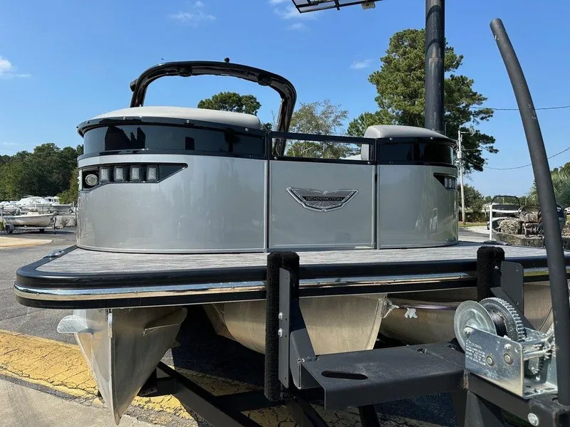Slide: The Image of 2021 Bennington 25 RXSB pontoon boat on trailer, parked outdoors. - 2