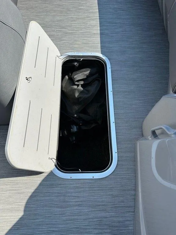 Slide: The Image of Open storage compartment on 2021 Bennington 25 RXSB boat, showing interior space. - 9