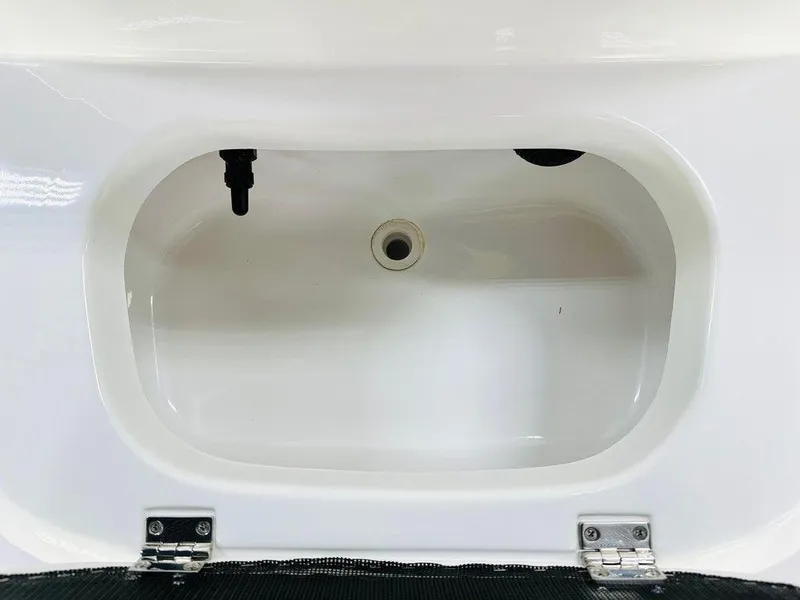 Slide: The Image of 2025 Frontier 180 boat storage compartment with white interior and metal hinges. - 3