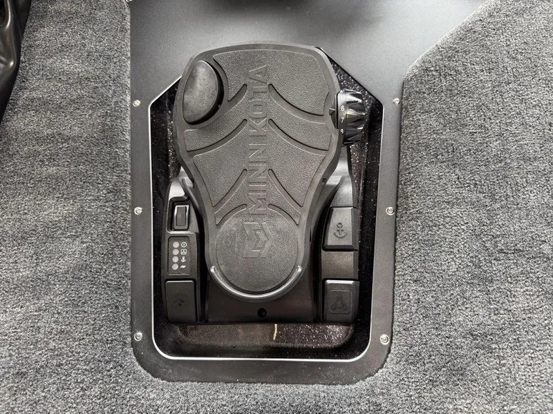 Slide: The Image of Minn Kota foot pedal on 2025 Skeeter ZXR20 boat, featuring control buttons and textured surface. - 2