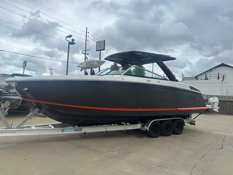 Slide: The Image of 2023 Cobalt R33 boat on trailer, sleek design, overcast sky background. - 0