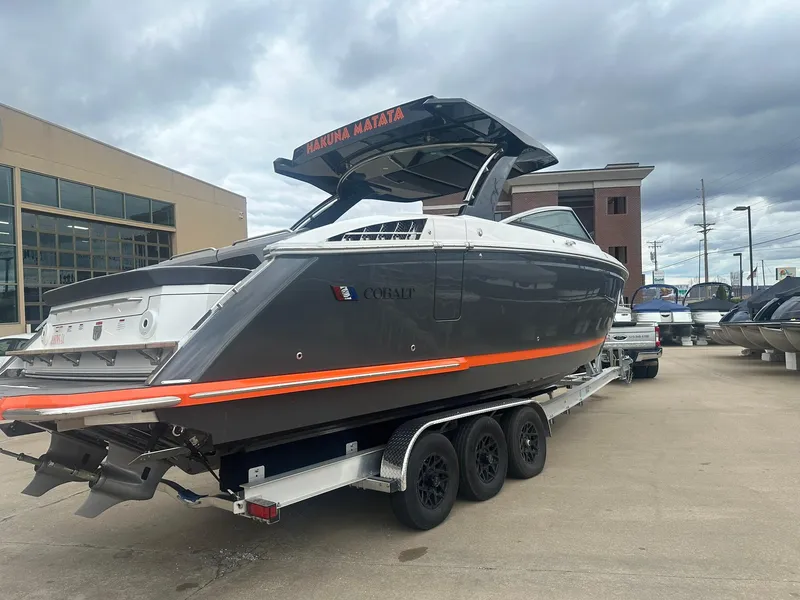 Slide: The Image of 2023 Cobalt R33 boat on trailer, gray with orange stripe, parked outdoors. - 1