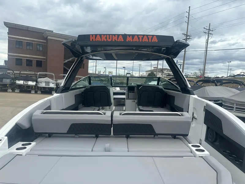 Slide: The Image of 2023 Cobalt R33 boat with "Hakuna Matata" sign, docked near a brick building. - 14