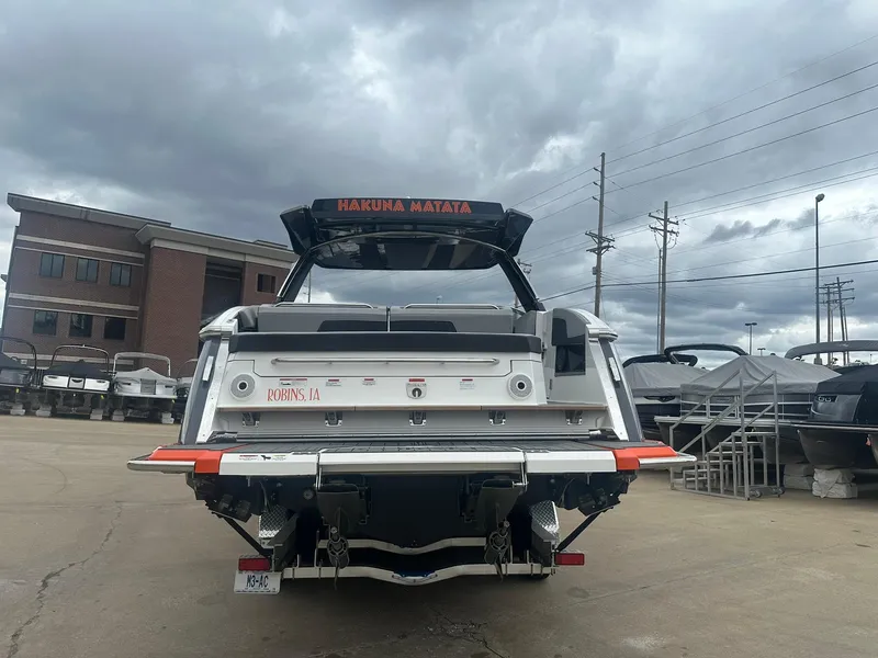 Slide: The Image of 2023 Cobalt R33 boat in a marina, overcast sky, rear view. - 2