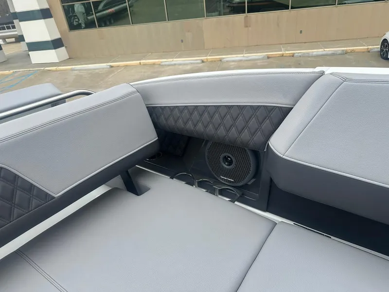 Slide: The Image of 2023 Cobalt R33 boat interior with gray cushioned seating and speaker system. - 22