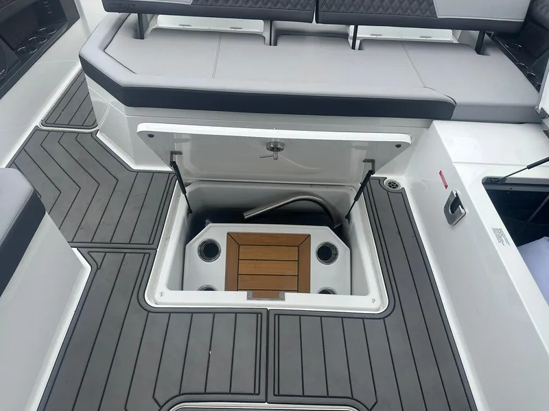 Slide: The Image of 2023 Cobalt R33 boat interior with open storage compartment and cushioned seating. - 33