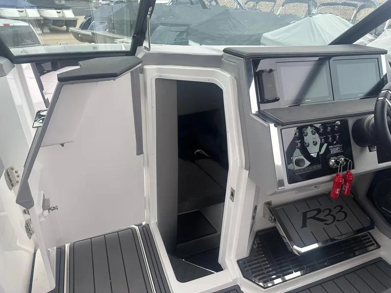 Slide: The Image of Cobalt R33 boat interior, featuring modern dashboard and open cabin door, 2023 model. - 38