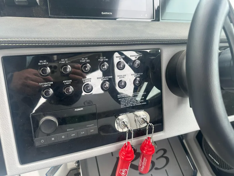 Slide: The Image of Control panel of a 2023 Cobalt R33 boat with switches and keys. - 44