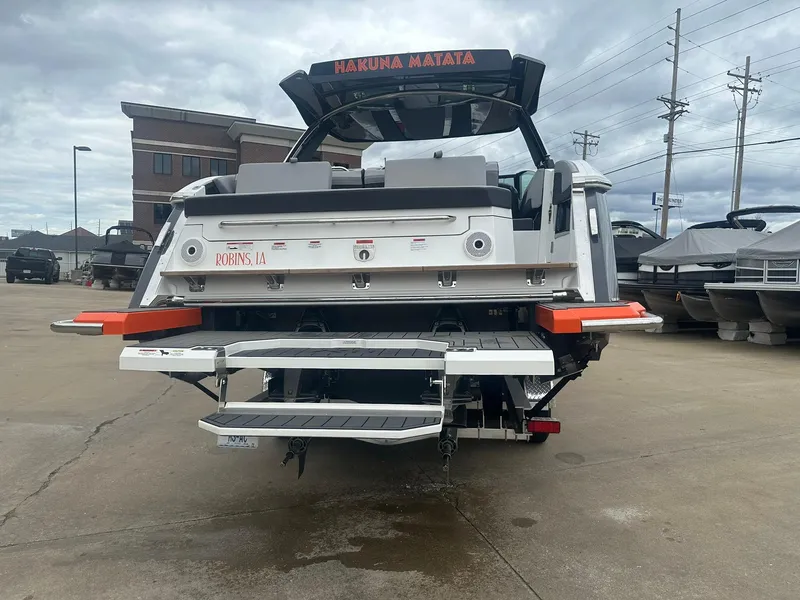 Slide: The Image of 2023 Cobalt R33 boat with swim platform, docked on concrete under cloudy skies. - 8