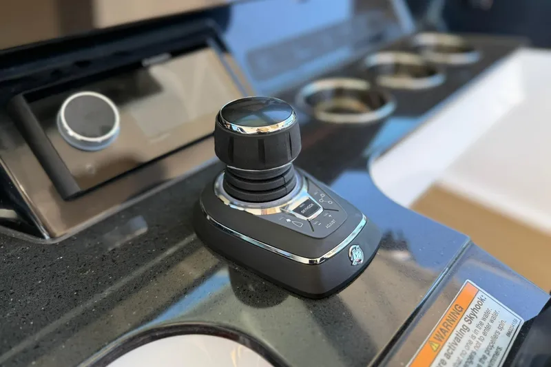 Slide: The Image of Joystick control on 2026 Monterey Elite 30 OB boat dashboard with cup holders. - 14