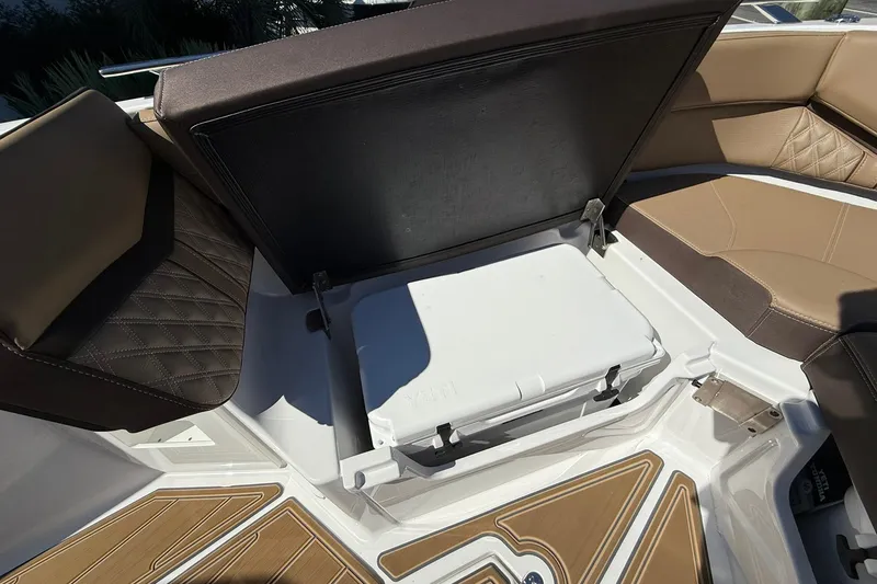 Slide: The Image of 2026 Monterey Elite 30 OB boat interior with open storage compartment and cushioned seating. - 5