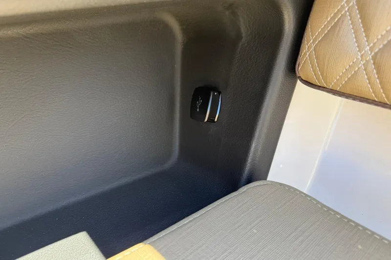 Slide: The Image of Interior detail of 2026 Monterey Elite 30 OB boat, featuring sleek upholstery and USB port. - 7