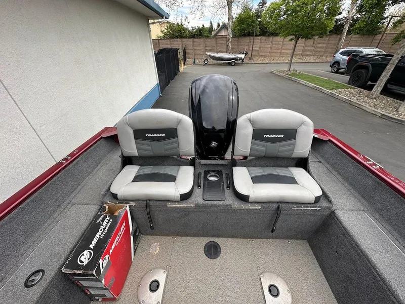 Slide: The Image of 2018 Tracker Pro Guide V-175 Combo boat interior with two seats and motor. - 10