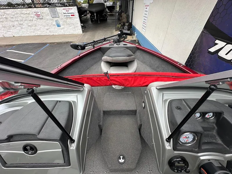 Slide: The Image of 2018 Tracker Pro Guide V-175 Combo boat interior with red accents and control panel. - 18