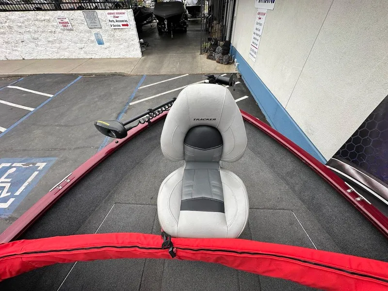 Slide: The Image of 2018 Tracker Pro Guide V-175 Combo boat with gray seat and red trim in parking lot. - 19