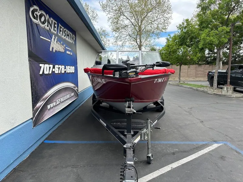 Slide: The Image of 2018 Tracker Pro Guide V-175 Combo boat on trailer, parked outside a fishing store. - 2