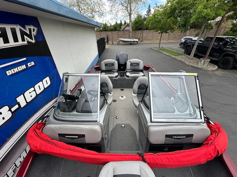Slide: The Image of 2018 Tracker Pro Guide V-175 Combo boat with dual windshields and seating, parked outdoors. - 22