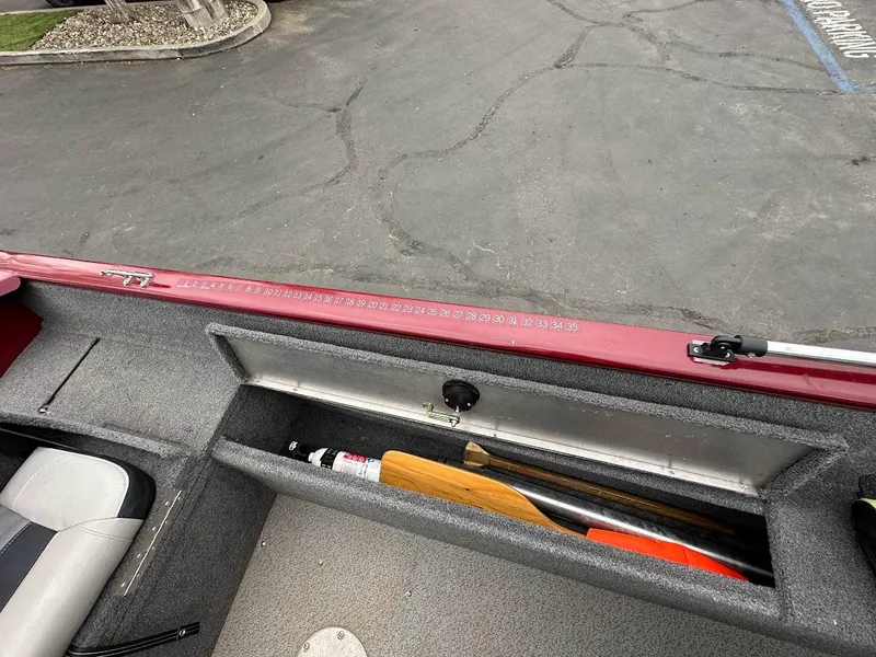 Slide: The Image of 2018 Tracker Pro Guide V-175 Combo boat storage compartment with paddle and equipment. - 23