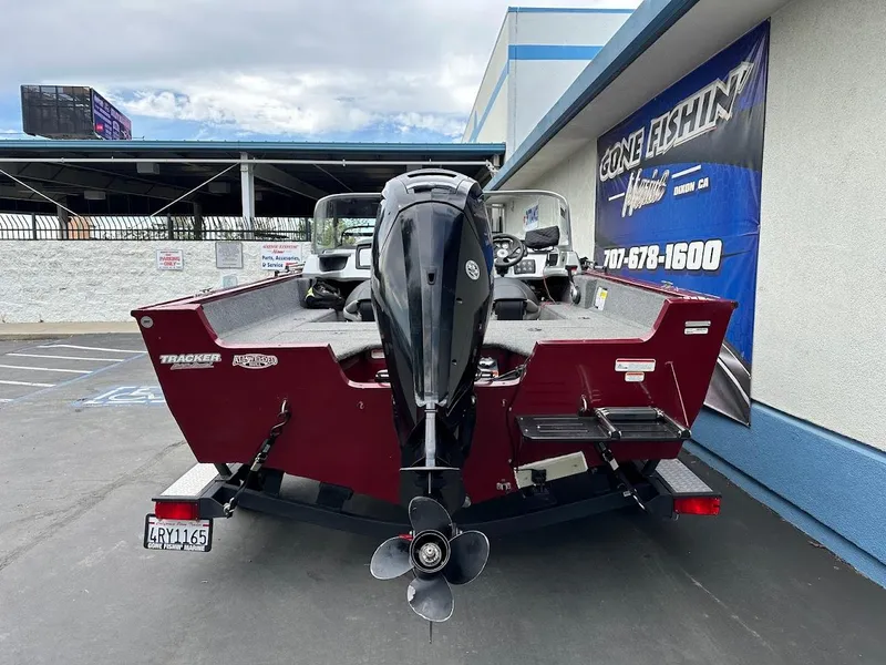Slide: The Image of 2018 Tracker Pro Guide V-175 Combo boat, rear view, parked near a building. - 8