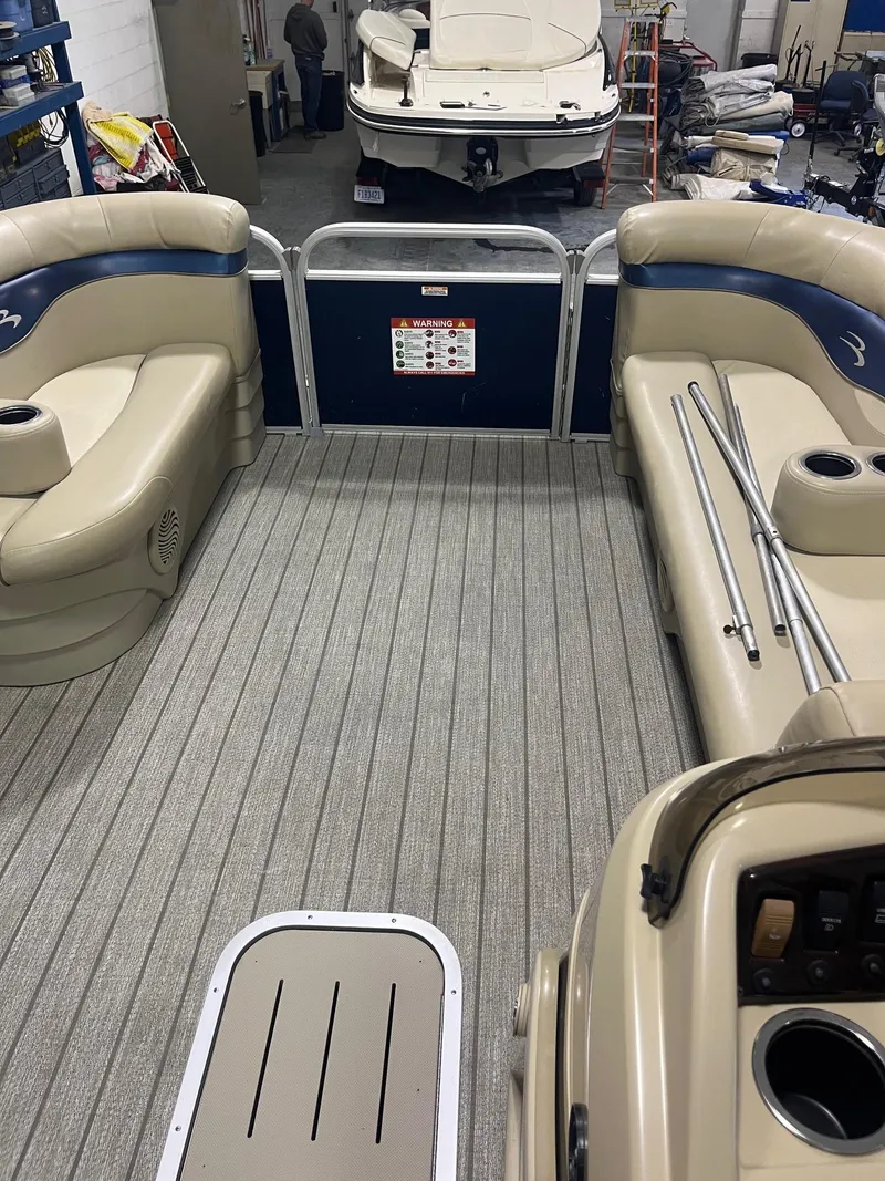 Slide: The Image of 2014 Bennington 22 SSLX pontoon boat interior with beige seating and gray flooring. - 3