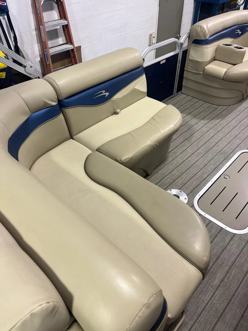 Slide: The Image of 2014 Bennington 22 SSLX boat interior with beige and blue seating on a gray deck. - 5