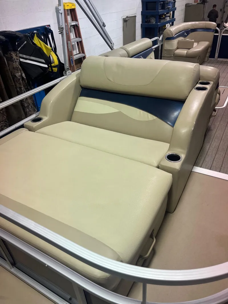 Slide: The Image of 2014 Bennington 22 SSLX boat with beige and blue seating, cup holders, and spacious deck. - 6