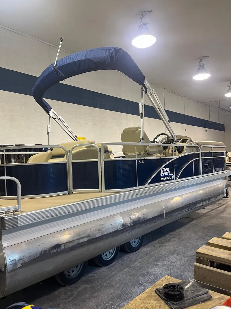 Slide: The Image of 2014 Bennington 22 SSLX pontoon boat in indoor storage with blue canopy. - 8