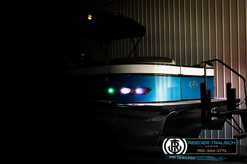 Slide: The Image of 2020 Avalon 2385 CAT EL boat in dimly lit storage, showcasing sleek design and vibrant blue accents. - 4