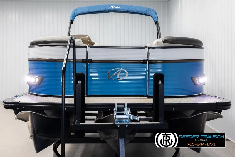 Slide: The Image of 2020 Avalon 2385 CAT EL pontoon boat with blue exterior, displayed indoors on a trailer. - 8